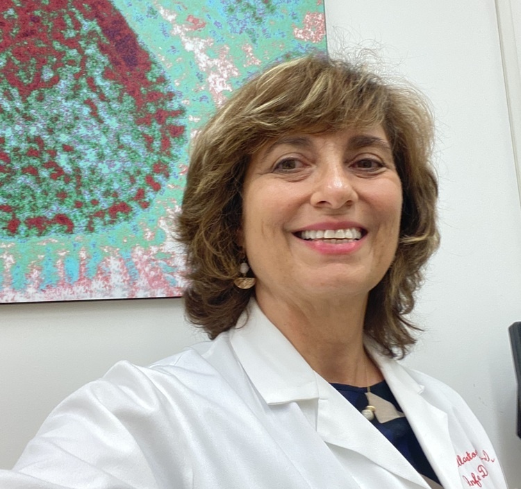 Dr. Mariella Salvatore in front of image of flu virus 