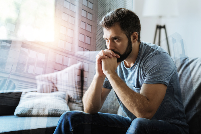 man resting his chin on folded hands