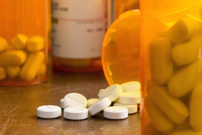 pill bottle spilt on its side with pills on the table